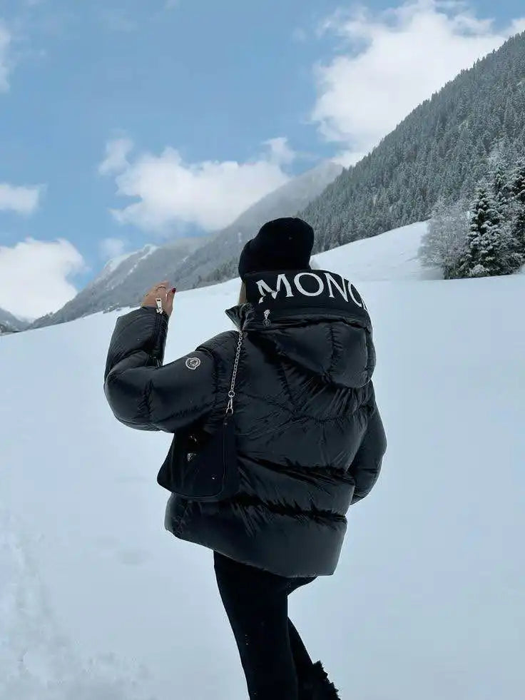 Doudoune noire Moncler portée dans un cadre enneigé.